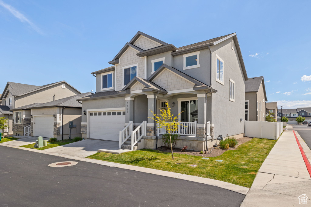 Craftsman house featuring concrete driveway, covered porch, a residential view, a garage, and stucco siding