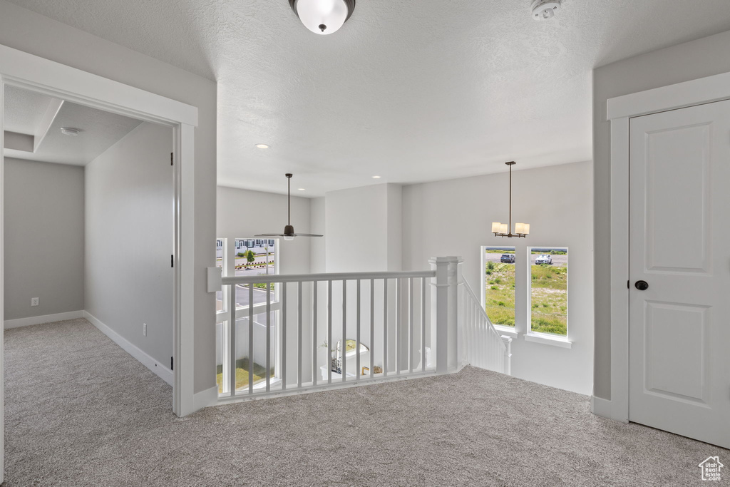 Hall featuring carpet floors, baseboards, an upstairs landing, a chandelier, and recessed lighting