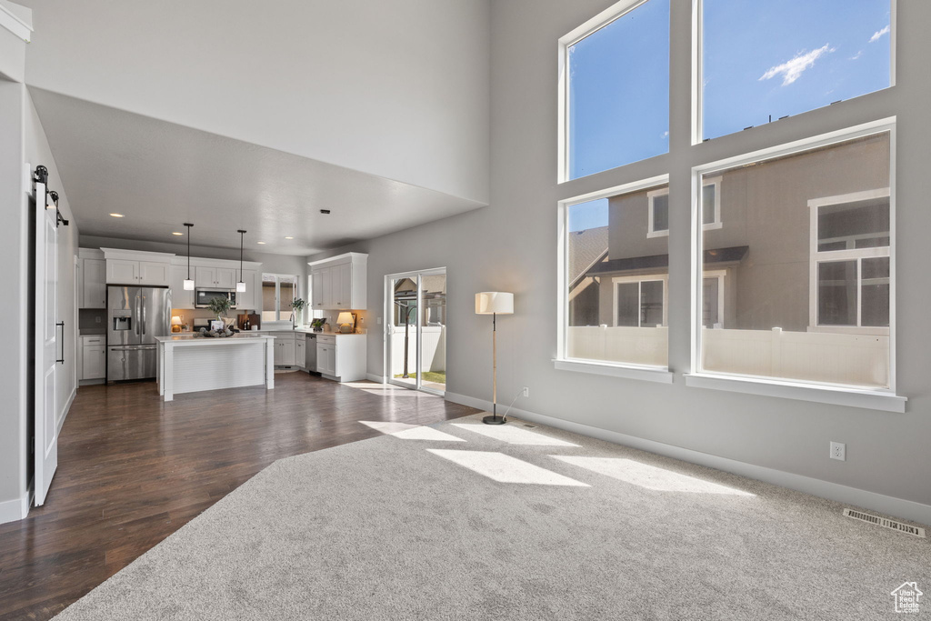 Unfurnished living room with recessed lighting, baseboards, and dark wood finished floors