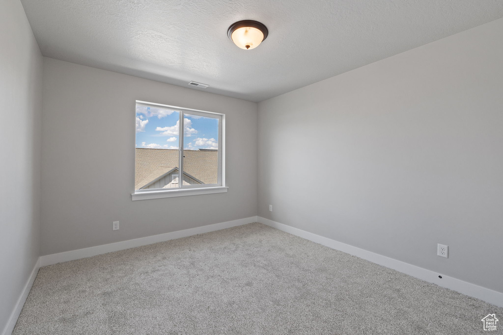 Carpeted spare room with baseboards