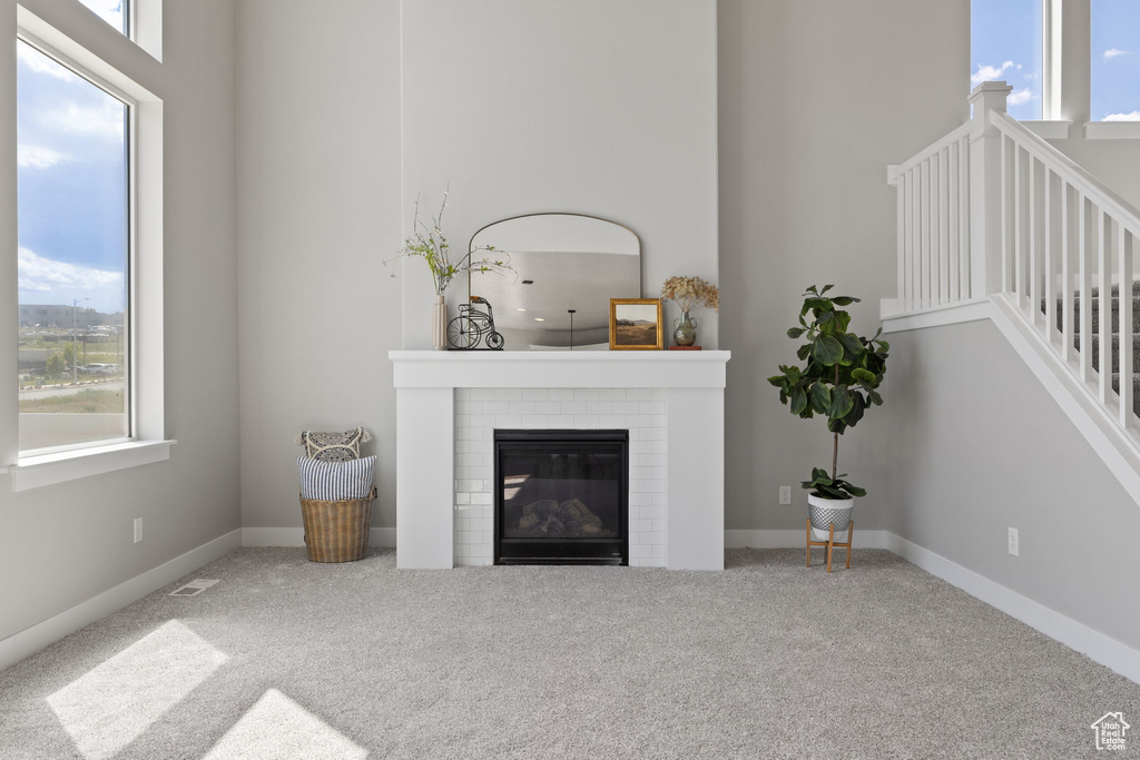 Living room with healthy amount of natural light, carpet floors, and a fireplace