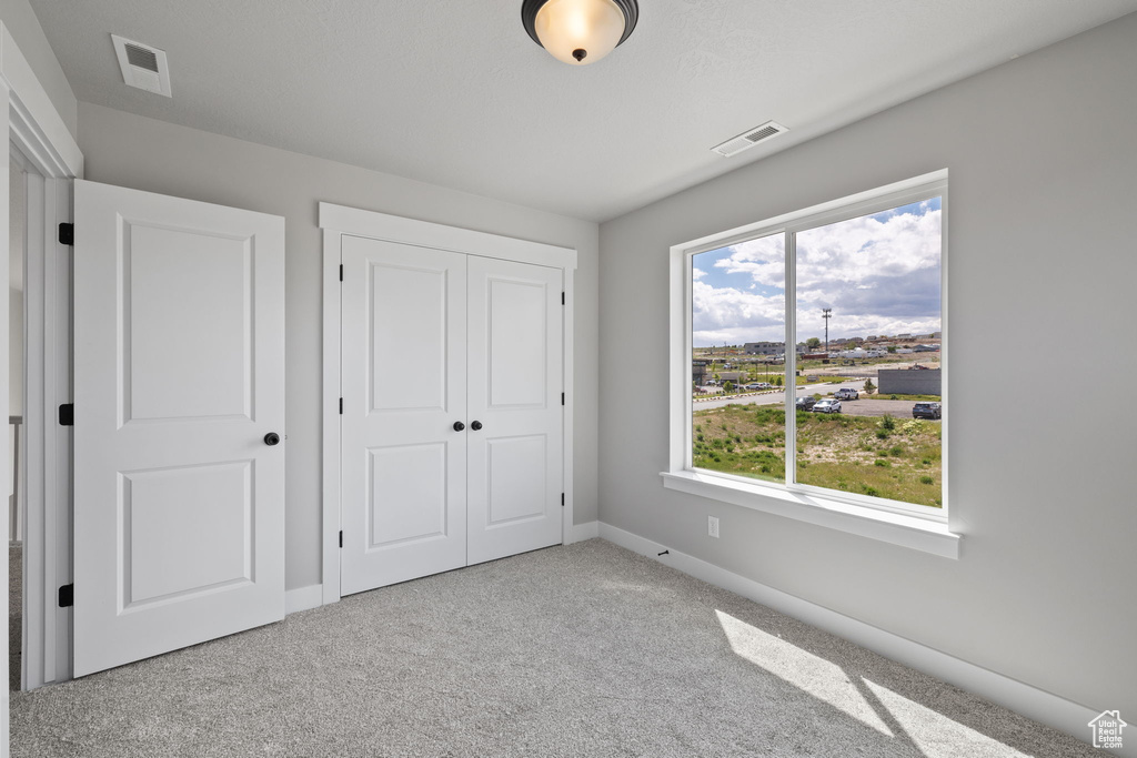 Unfurnished bedroom featuring baseboards, carpet floors, and a closet