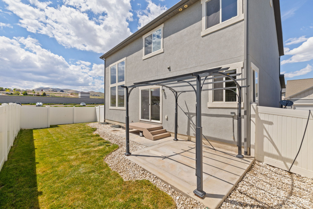Rear view of house featuring a patio, stucco siding, and a pergola