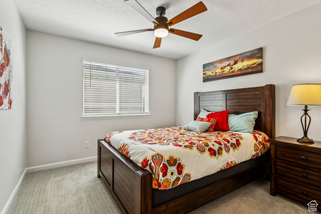 Carpeted bedroom featuring baseboards and a ceiling fan