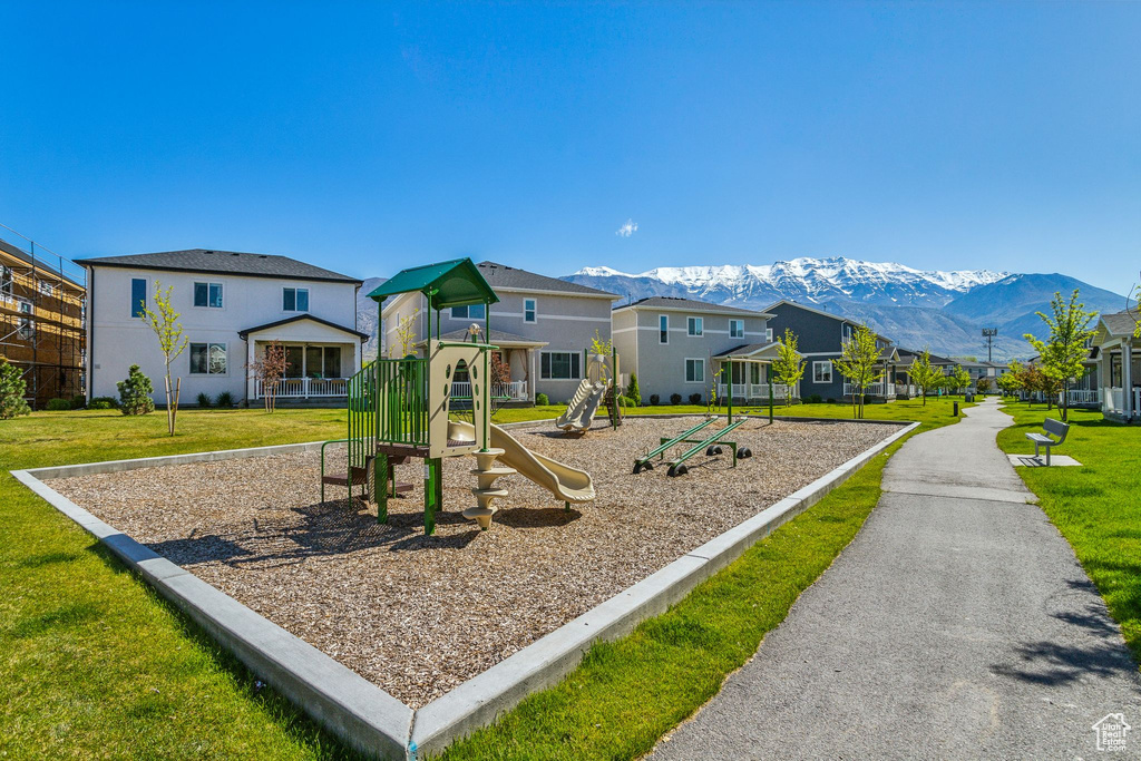 Communal playground featuring a mountain view, a yard, and a residential view