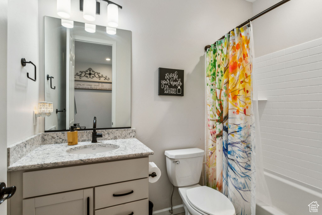 Full bathroom featuring vanity, toilet, and shower / bath combo with shower curtain