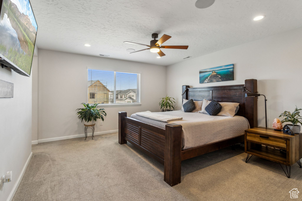Bedroom with light carpet, baseboards, recessed lighting, ceiling fan, and a textured ceiling