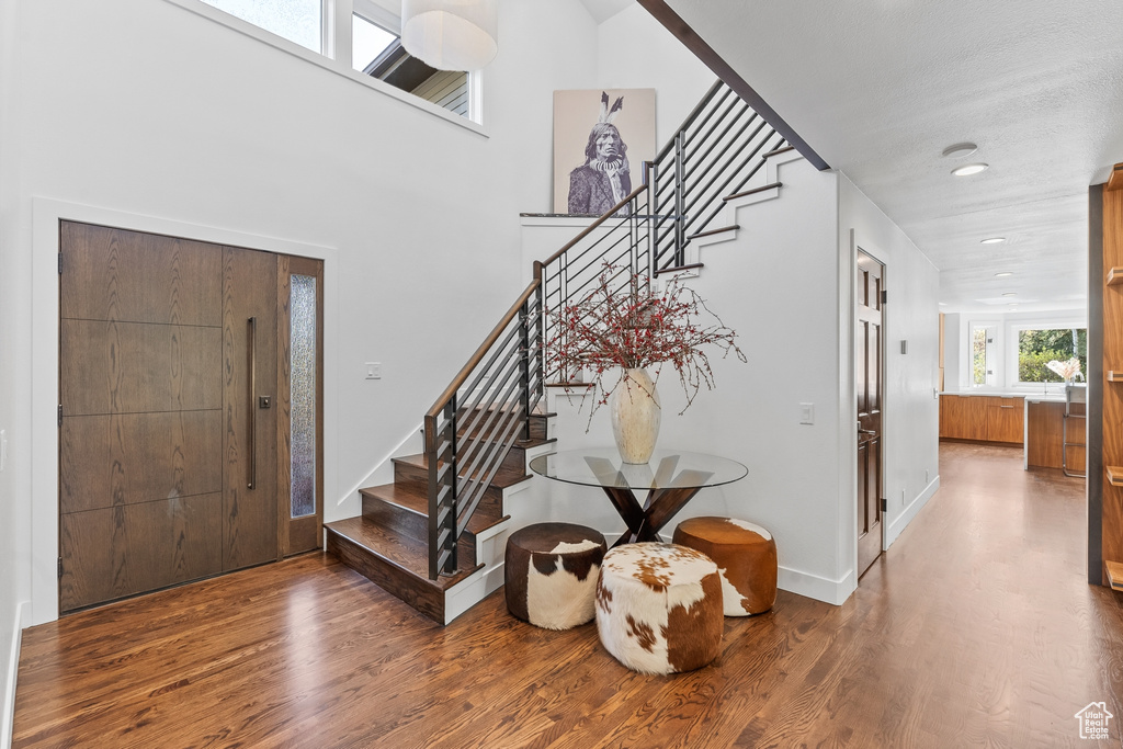 Entrance foyer featuring stairs, wood finished floors, baseboards, and recessed lighting