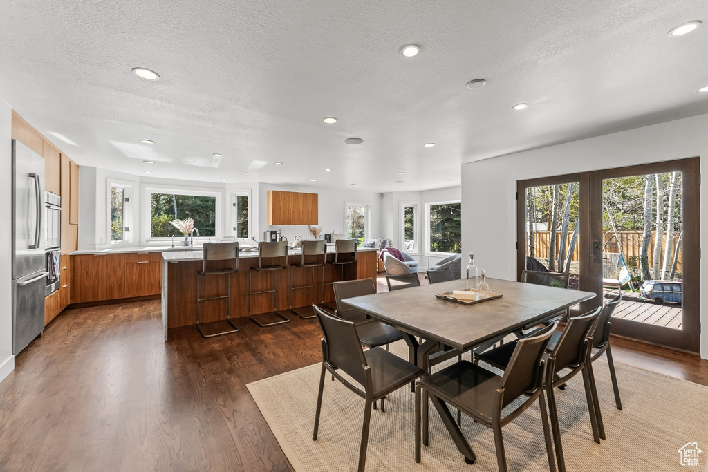 Dining space featuring wood finished floors, plenty of natural light, recessed lighting, french doors, and a textured ceiling