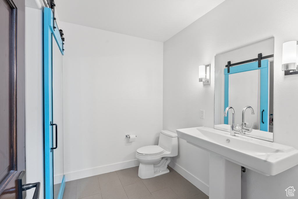 Bathroom with baseboards, tile patterned floors, and toilet