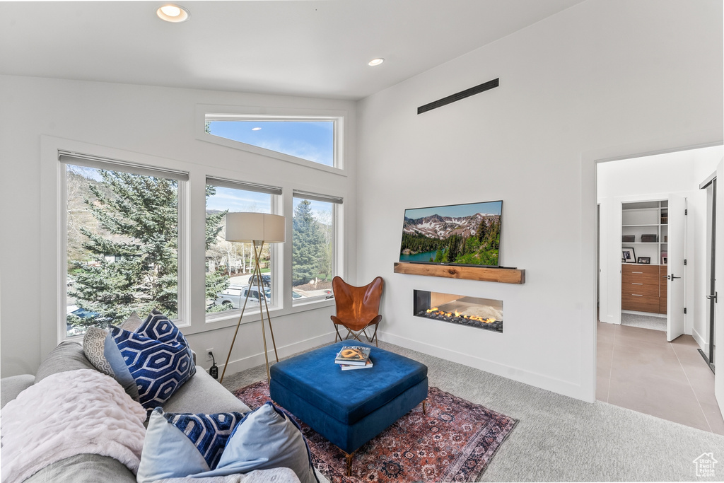 Carpeted living room featuring a glass covered fireplace, recessed lighting, and baseboards