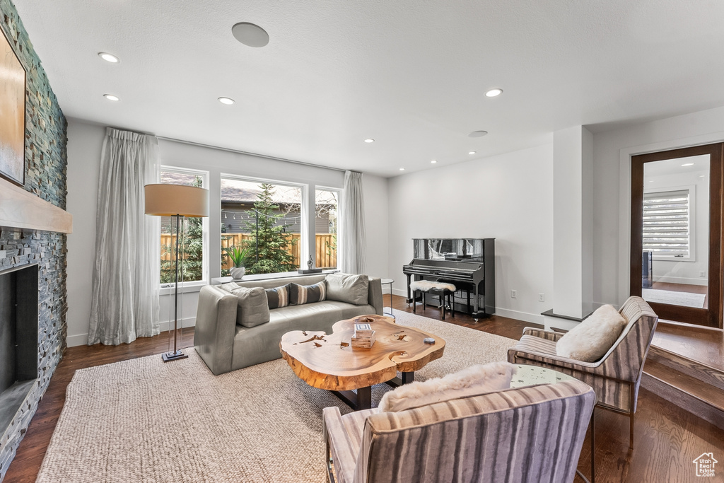 Living room featuring wood finished floors, a fireplace, recessed lighting, and baseboards