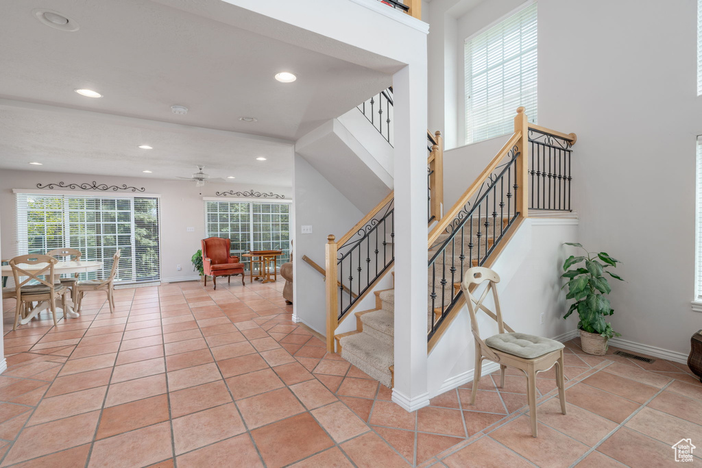 Staircase featuring a ceiling fan, recessed lighting, baseboards, and tile patterned floors