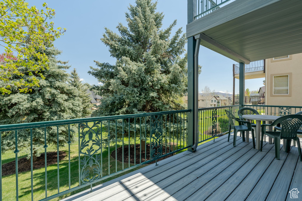 Wooden terrace with outdoor dining space and a lawn