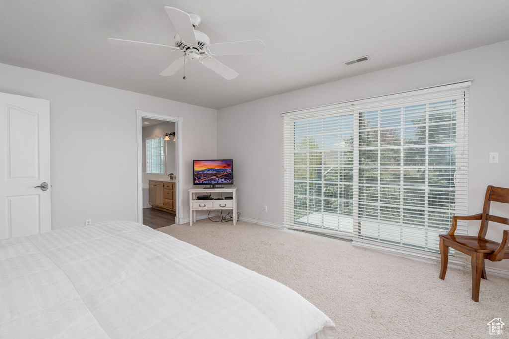 Bedroom featuring multiple windows, carpet, baseboards, and ceiling fan