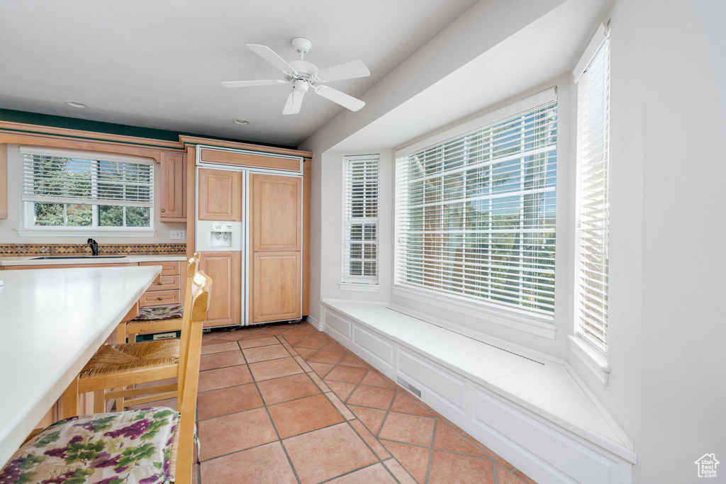 Kitchen featuring light countertops, a sink, light tile patterned floors, and plenty of natural light