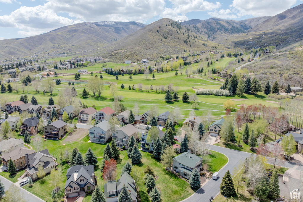View of property location featuring nearby suburban area, a mountainous background, and a local golf course