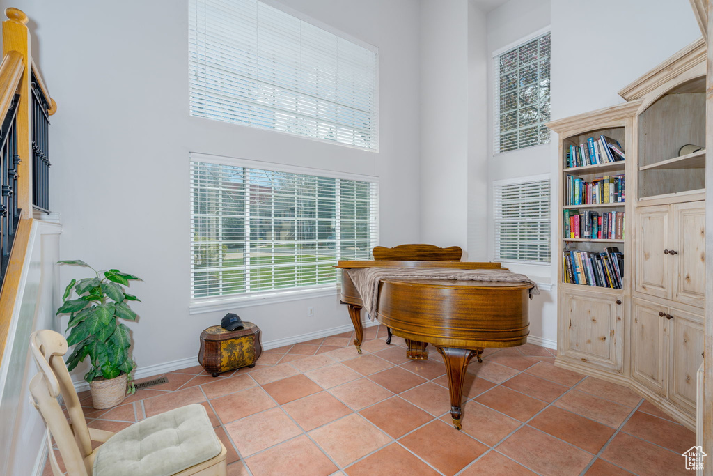 Sitting room featuring a towering ceiling, baseboards, and light tile patterned floors