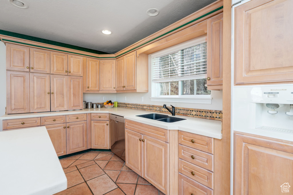Kitchen featuring dishwasher, light brown cabinets, a sink, light tile patterned floors, and recessed lighting