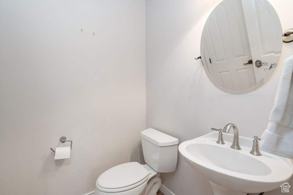 Bathroom with baseboards, toilet, and a sink
