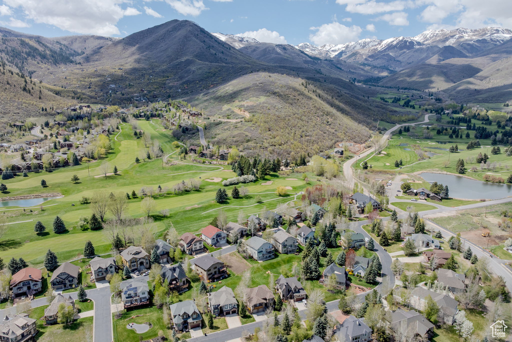 Aerial overview of property\'s location with a water and mountain view, a local golf course, and nearby suburban area