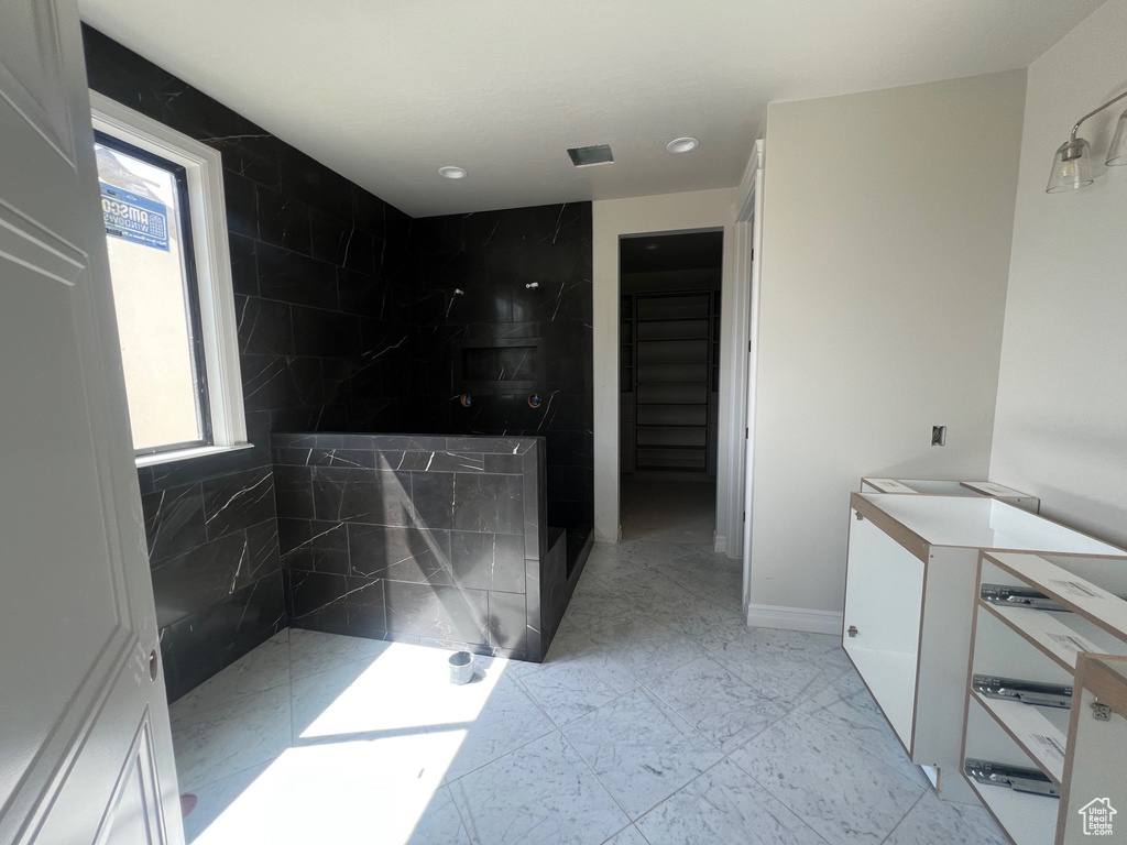 Bathroom with walk in shower, vanity, marble look tiles, and recessed lighting