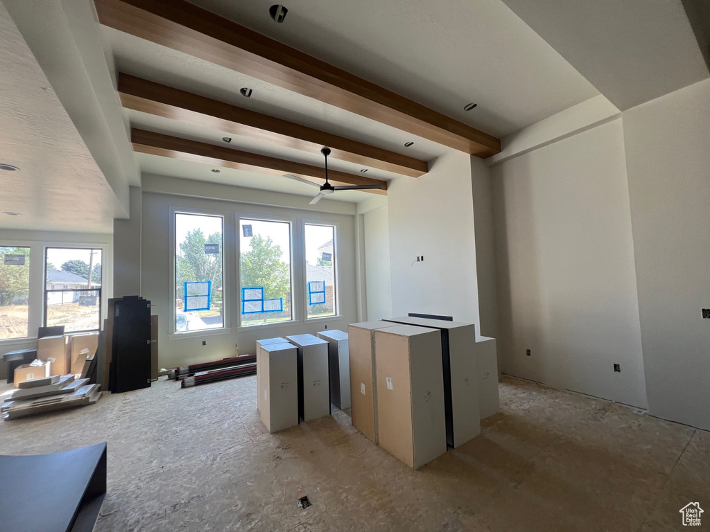 Living room featuring beam ceiling and a ceiling fan