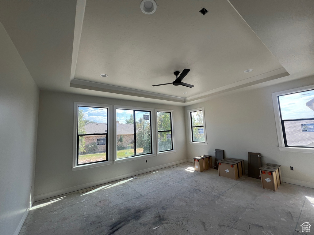 Spare room with a tray ceiling and a ceiling fan
