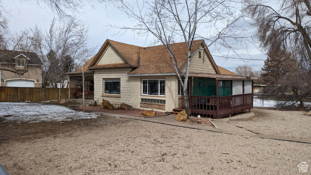 Back of property with roof with shingles and fence