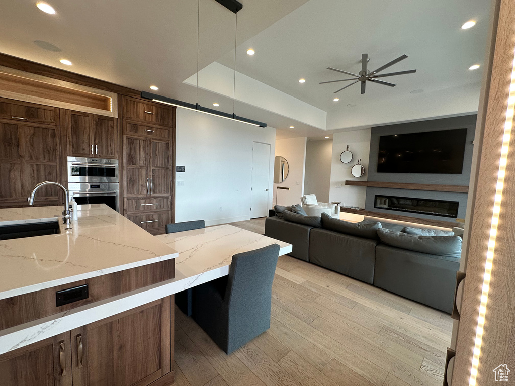Kitchen with a sink, a ceiling fan, stainless steel double oven, recessed lighting, and pendant lighting
