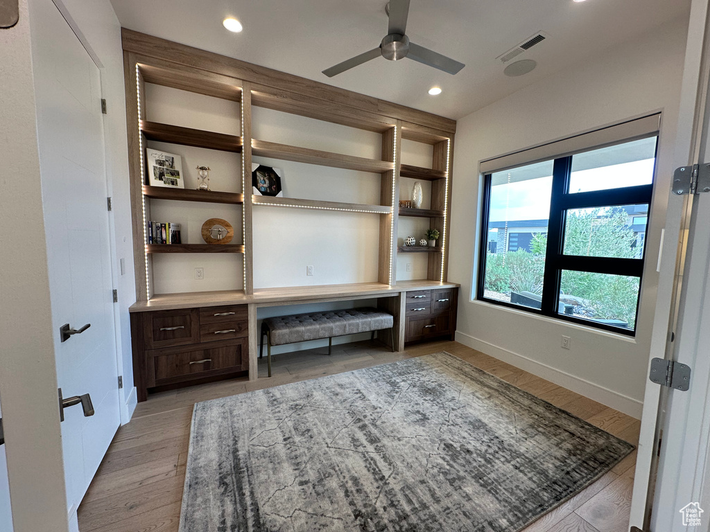 Unfurnished office featuring ceiling fan, light wood-style floors, baseboards, recessed lighting, and built in study area