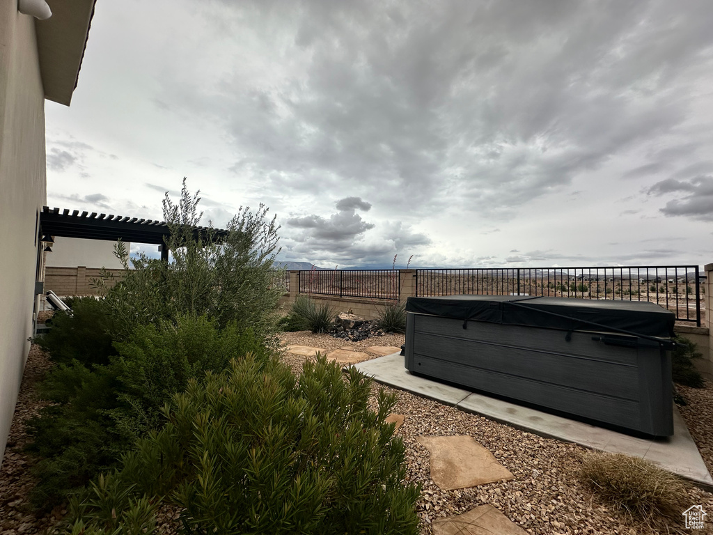 Fenced backyard featuring a hot tub