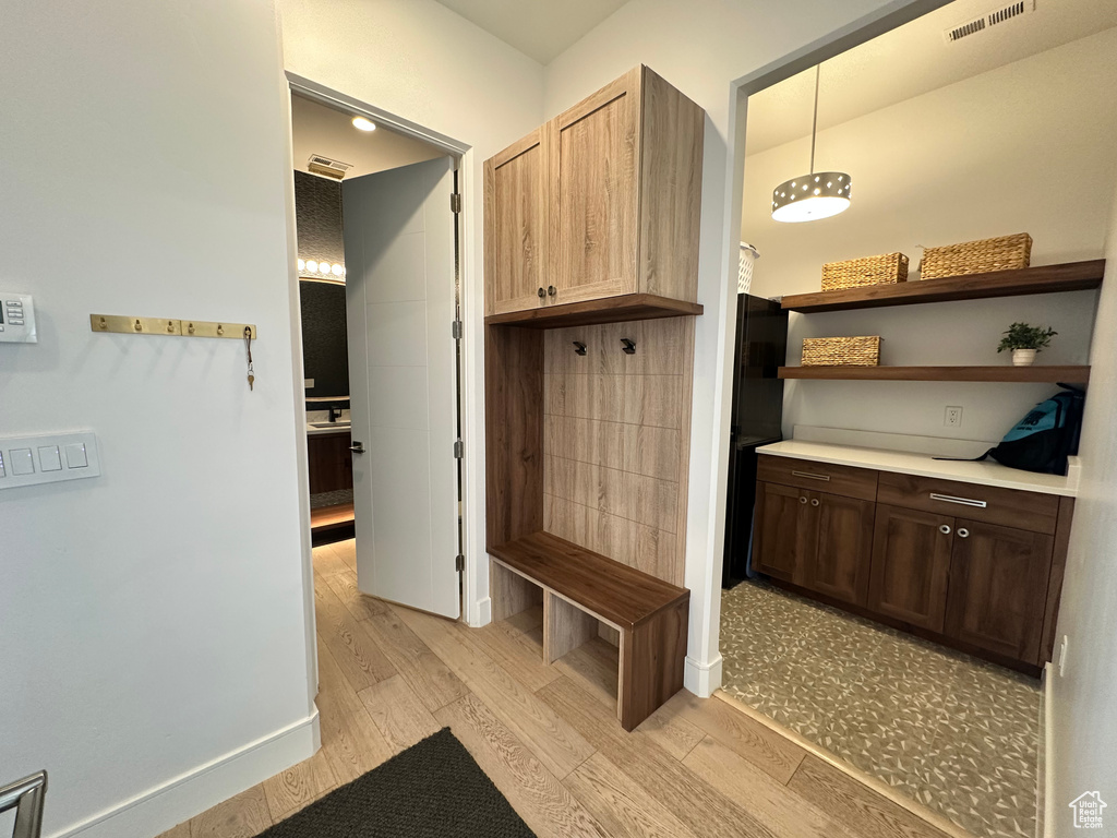 Mudroom with light wood-style floors and baseboards