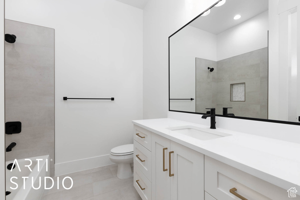Full bathroom featuring tiled shower, toilet, vanity, baseboards, and tile patterned flooring