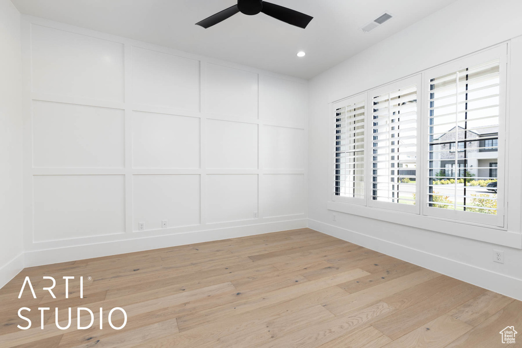 Empty room with a ceiling fan, a decorative wall, light wood-style flooring, baseboards, and recessed lighting
