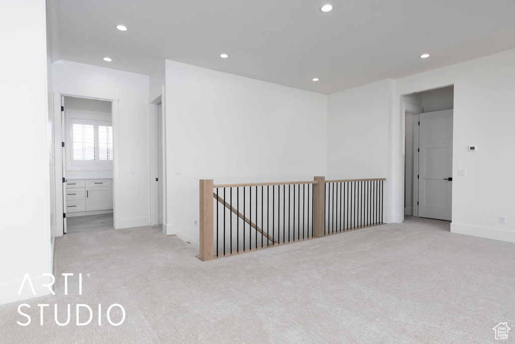 Empty room with light carpet, recessed lighting, and baseboards