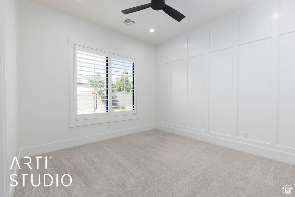 Spare room featuring carpet, a decorative wall, ceiling fan, baseboards, and recessed lighting