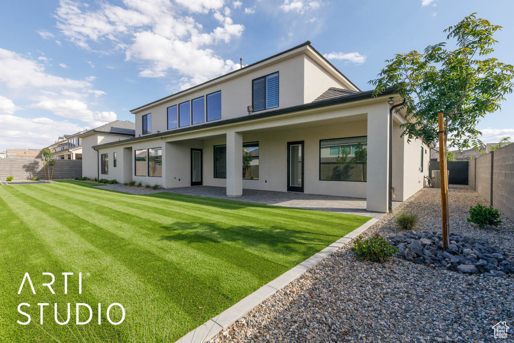 Rear view of property featuring stucco siding and a patio area
