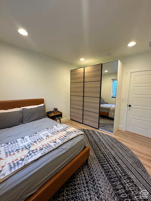 Bedroom with light wood-style flooring, recessed lighting, and baseboards