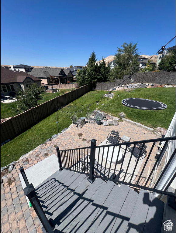 View of patio featuring a trampoline and a residential view