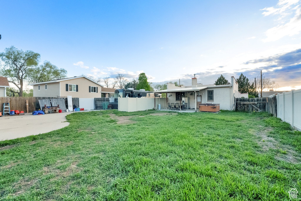 View of yard featuring a hot tub and a patio