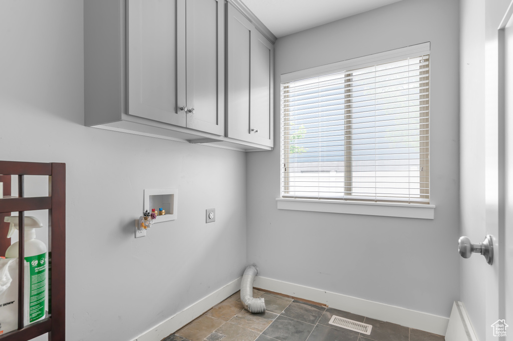 Laundry area with hookup for an electric dryer, hookup for a washing machine, baseboards, and cabinet space