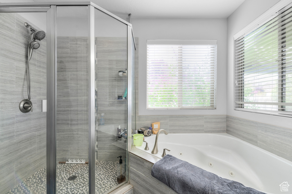 Bathroom featuring a whirlpool tub and a shower stall