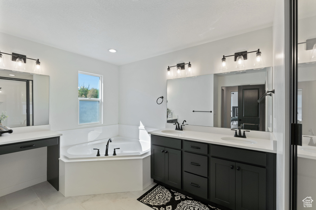 Full bath featuring double vanity, a bath, and a shower