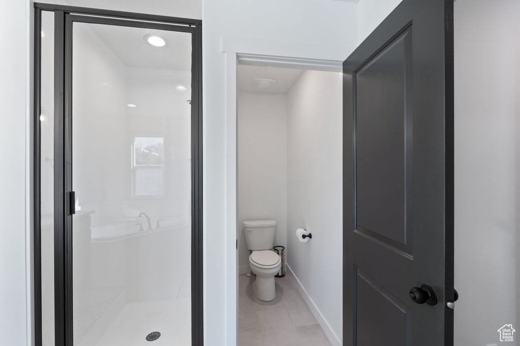 Full bath with baseboards, a stall shower, and toilet