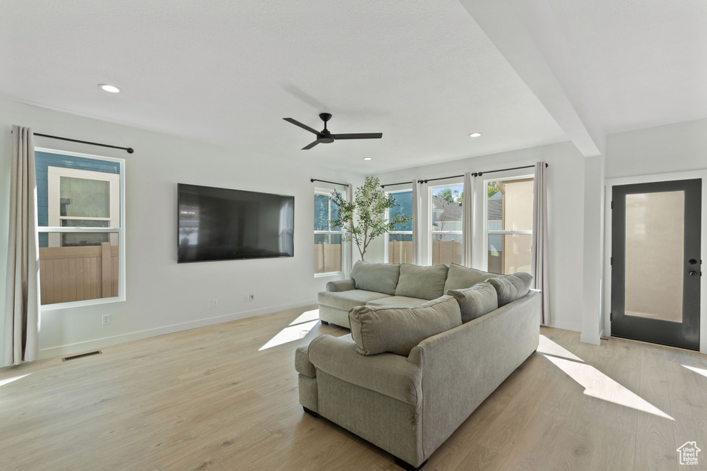 Living area featuring light wood-style flooring, a ceiling fan, recessed lighting, and baseboards