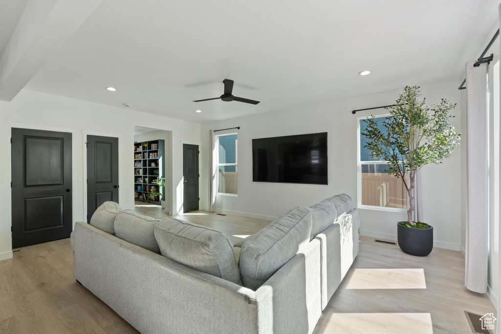 Living room with light wood-style flooring, ceiling fan, baseboards, and recessed lighting