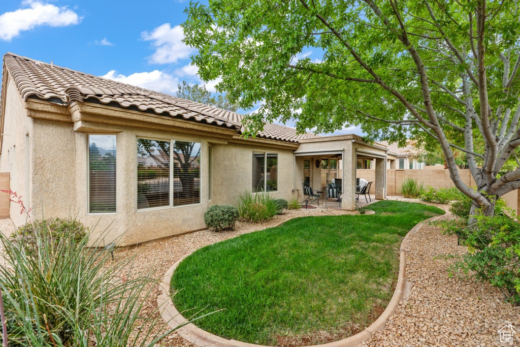 Back of house with stucco siding, a patio, and a tile roof