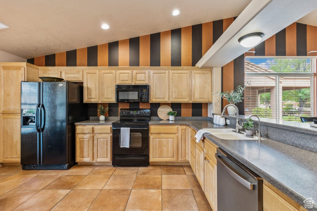 Kitchen featuring black appliances, wallpapered walls, light brown cabinetry, a sink, and recessed lighting