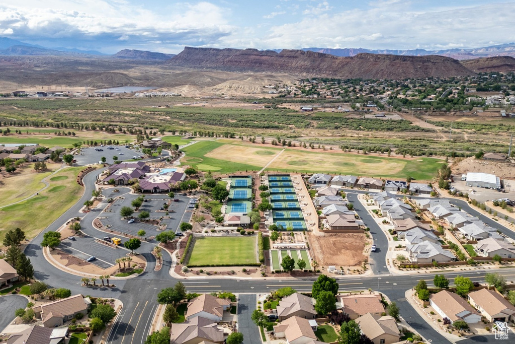 Aerial view of property's location featuring a golf course, nearby suburban area, and a water and mountain view